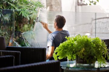 Man lathers soapy liquid on a window