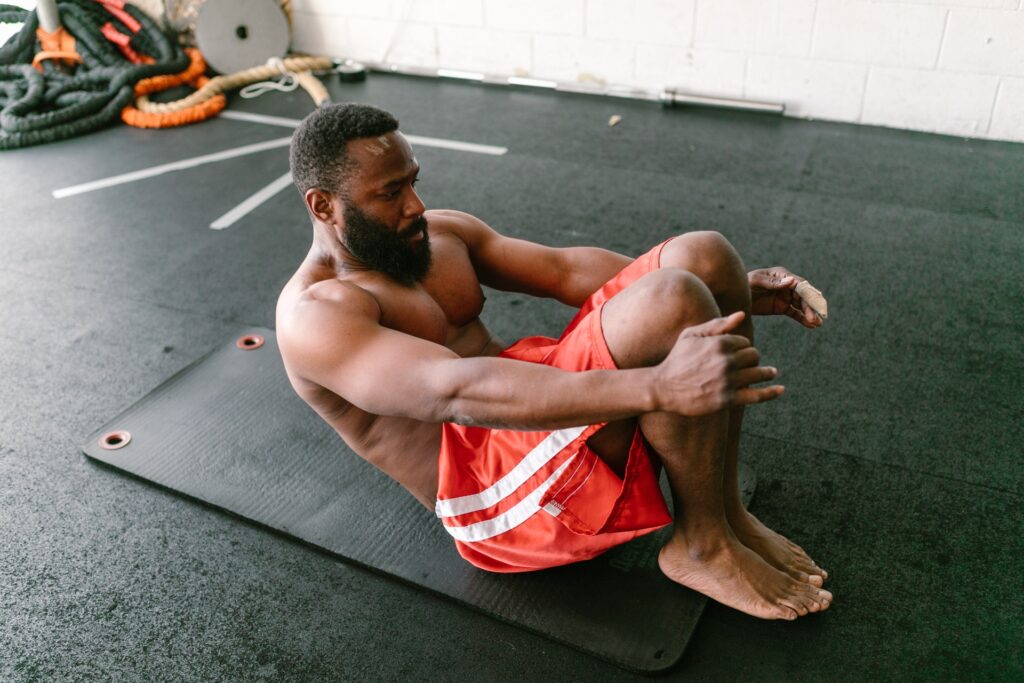 Man performs ab crunch on a mat in a a gym