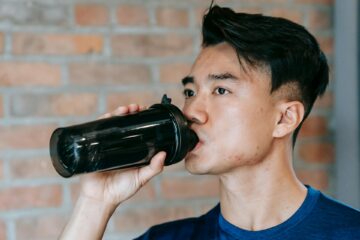 Asian man drinks water from a water bottle