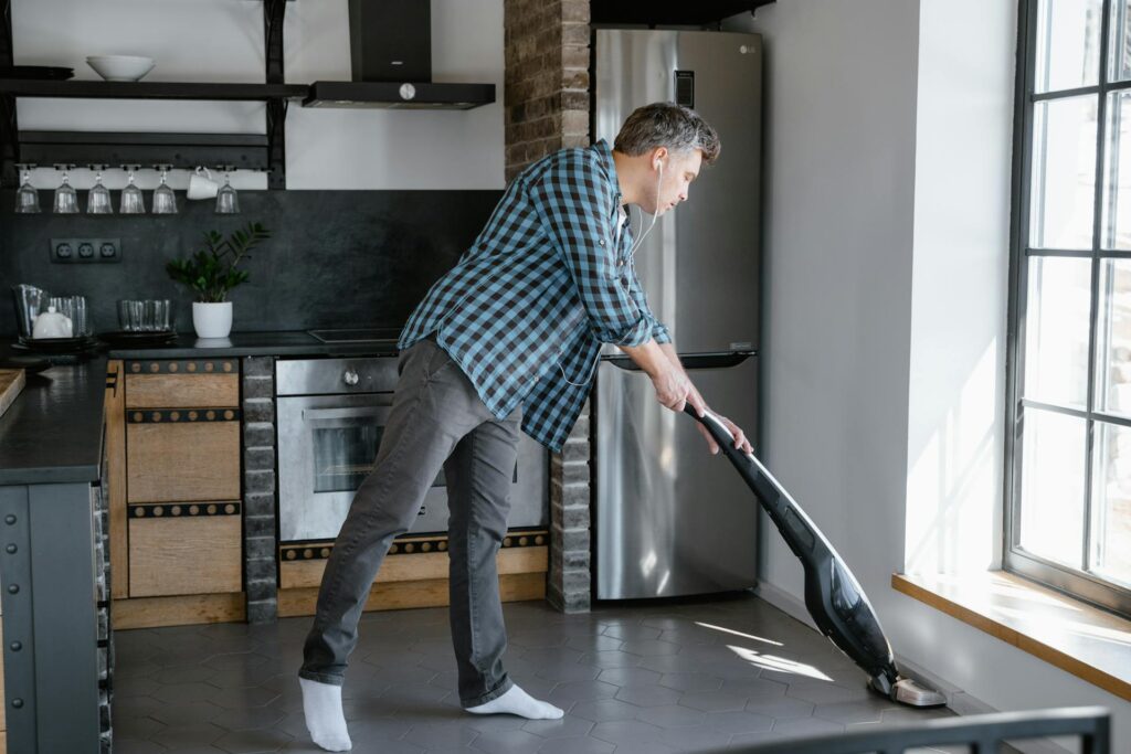 Man pushes vacuum cleaner across the floor
