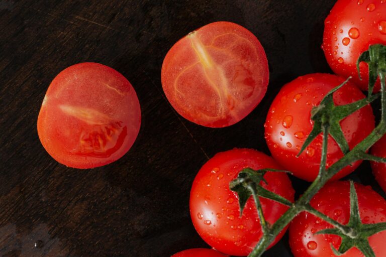 Several whole and halved tomatoes arranged on a table